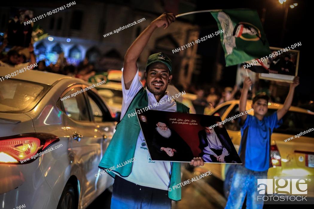 Stock Photo: 11 October 2021, Iraq, Baghdad: Supporters of Iraqi Shiite cleric Moqtada al-Sadr celebrate at Tahrir square following the announcement of parliamentary.