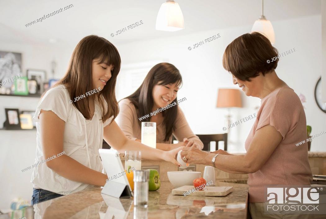 Stock Photo: Grandmother, mother and daughter preparing food.