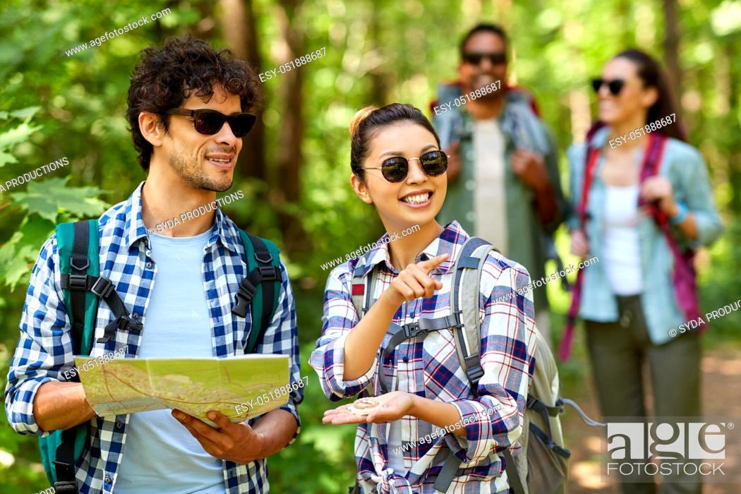 Stock Photo: friends with map and backpacks hiking in forest.