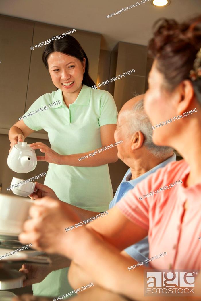 Stock Photo: Parents with adult daughter having breakfast.