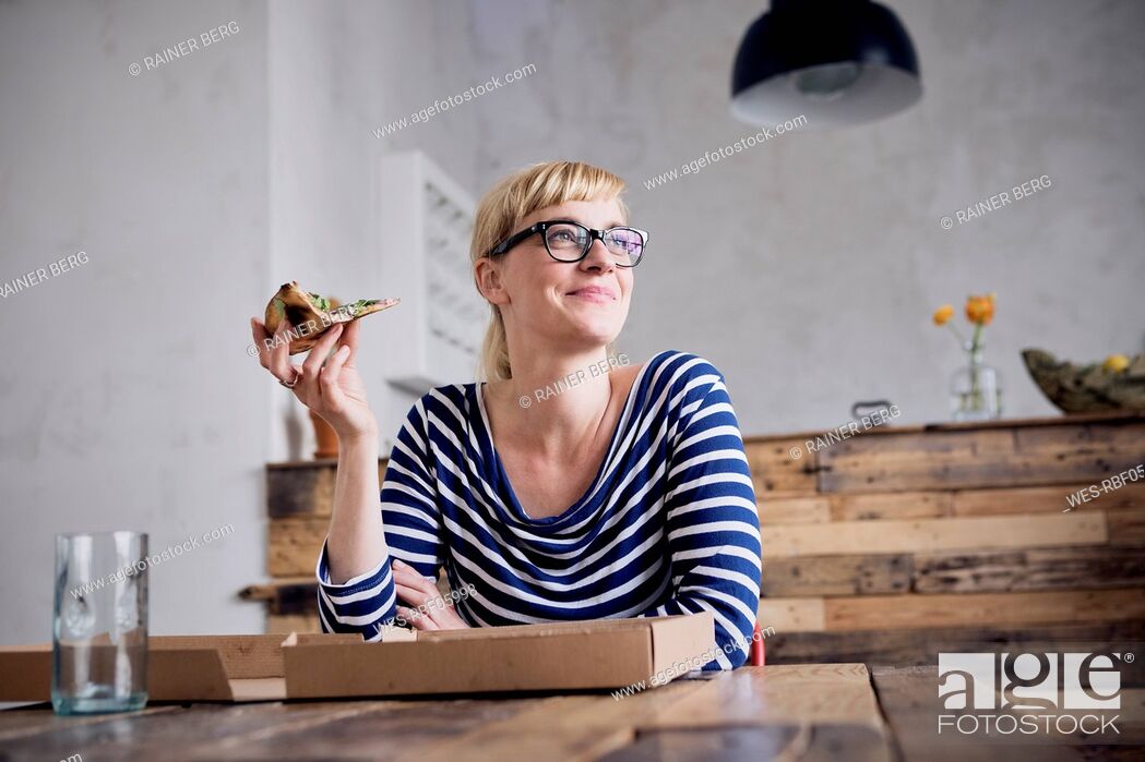 Stock Photo: Portrait of smiling woman eating pizza.