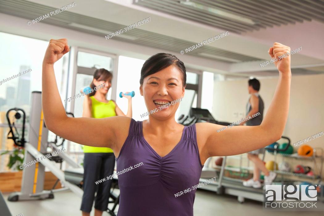 Stock Photo: Mature women showing her strength after workout in the gym.