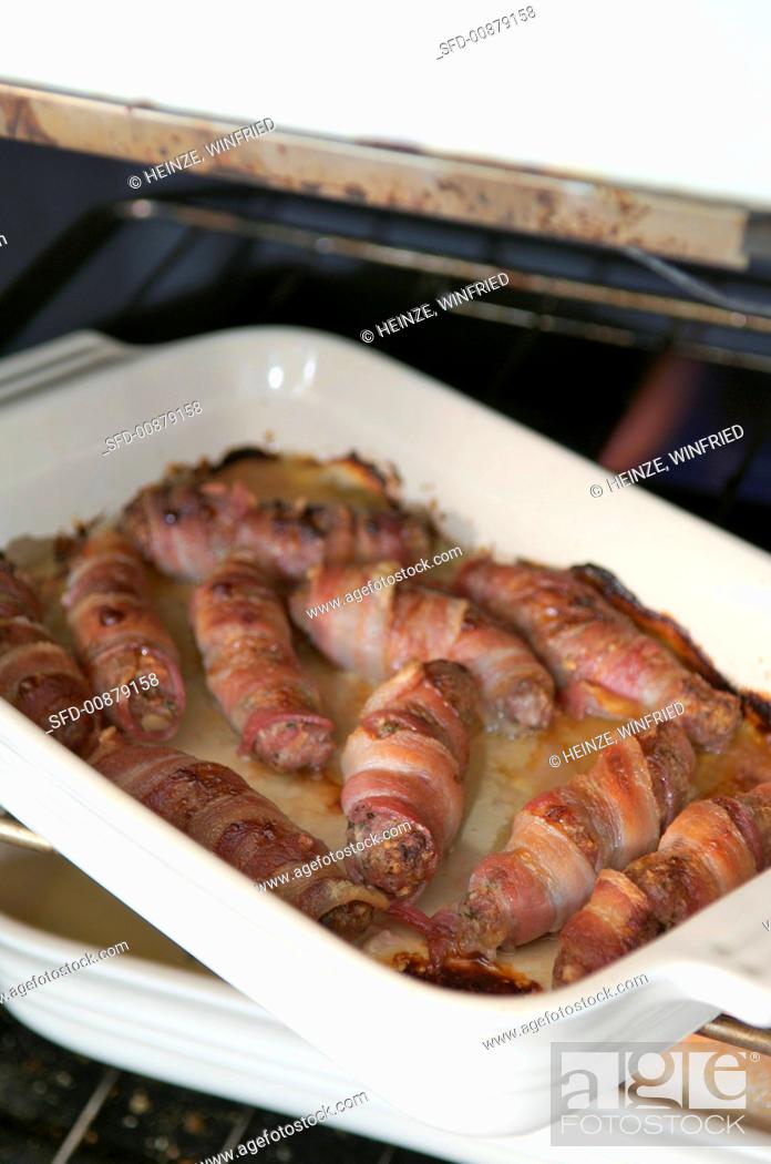Stock Photo: Bacon-wrapped sausages with herbs, apple and nuts.