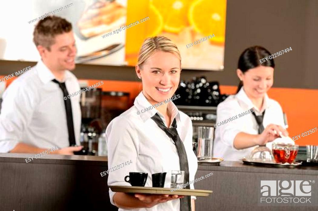 Stock Photo: Confident waitress serving coffee with tray.