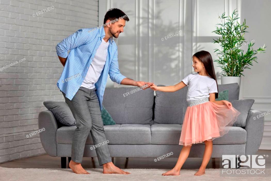 Imagen: Handsome dad dancing with his little cute daughter at home. Father's Day.