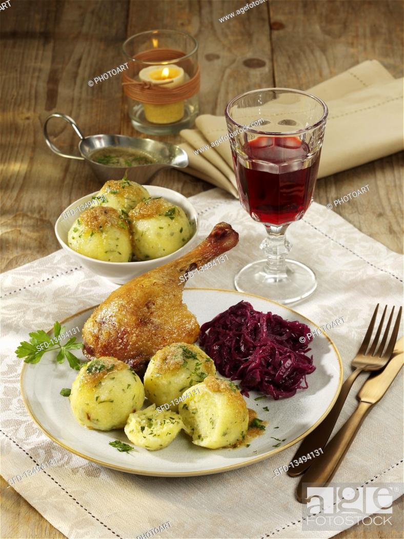 Photo de stock: Duck leg with herb dumplings and red cabbage.
