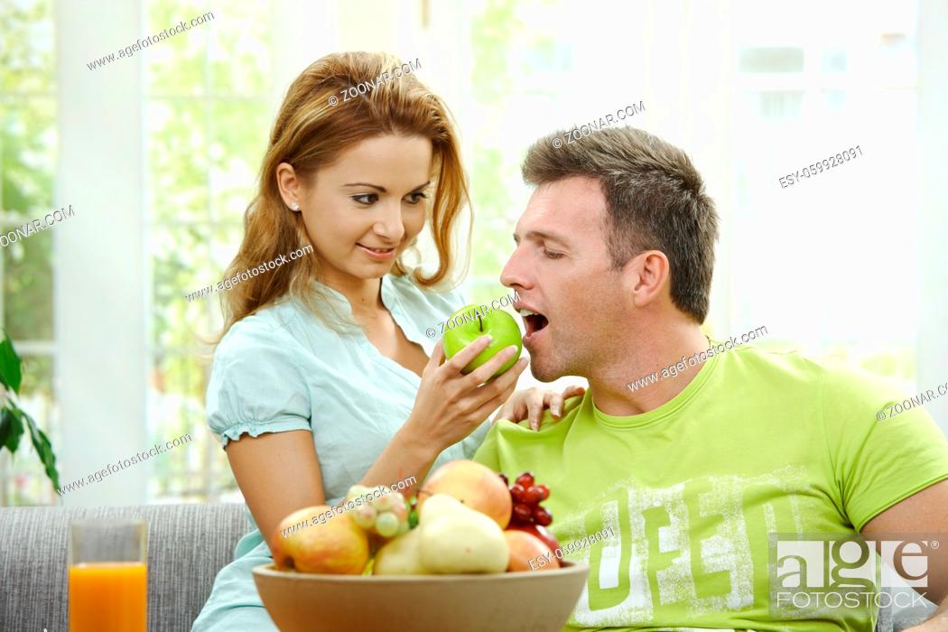 Stock Photo: Love couple having breakfast together. Woman giving apple to her boyfriend.