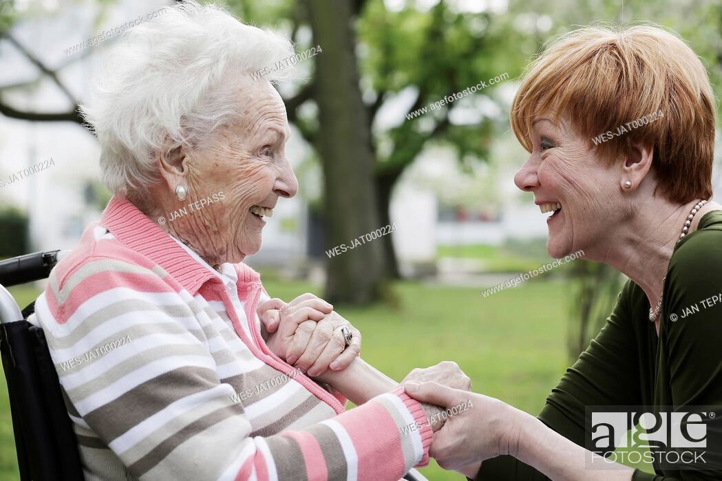 Imagen: Germany, North Rhine Westphalia, Cologne, Senior woman and mature woman looking at each other, smiling.