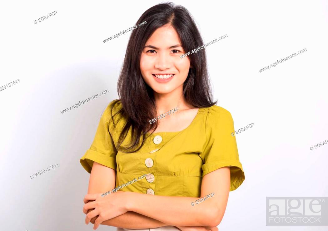 Imagen: Portrait Asian beautiful young woman standing smile seeing white teeth, She crossed her arms and looking at camera, shoot photo in studio on white background.