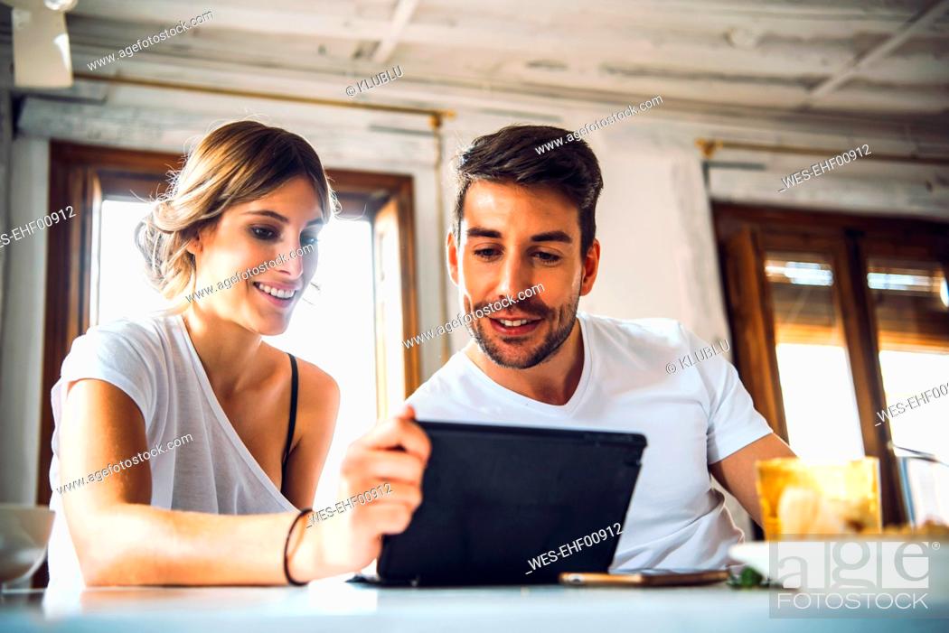 Stock Photo: Young couple watching tablet at home.