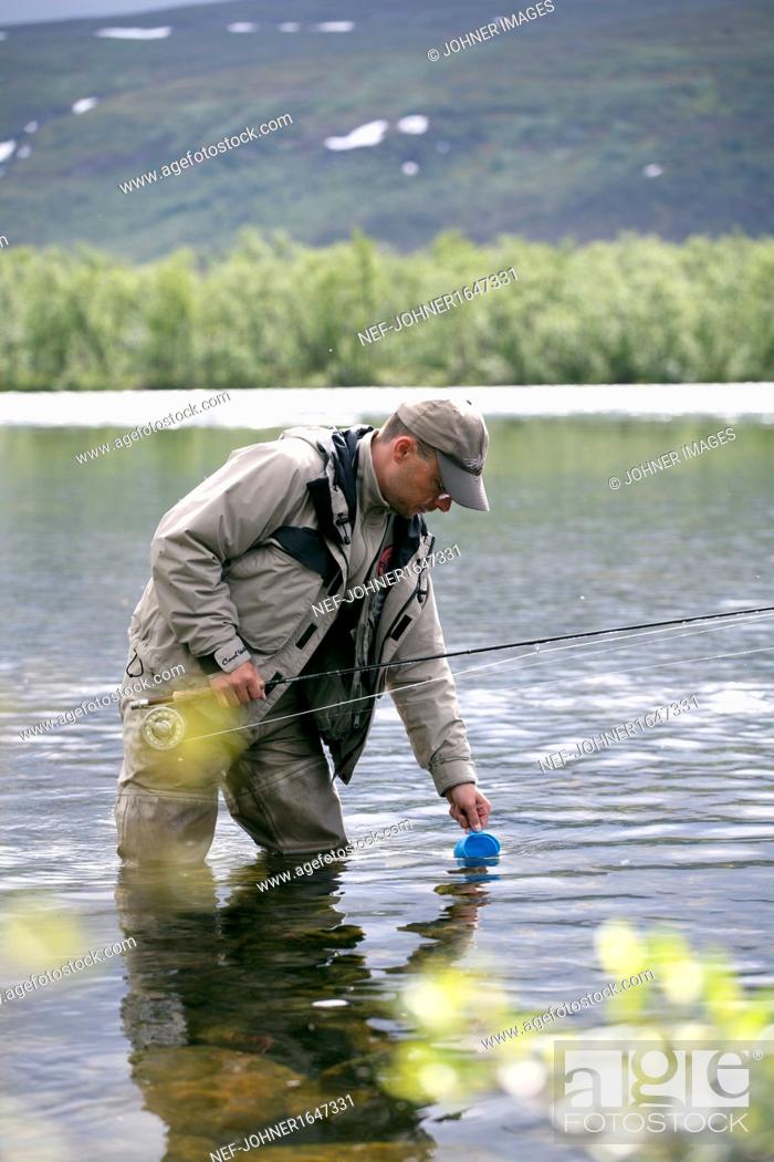 Stock Photo: Man fishing in mountain lake.