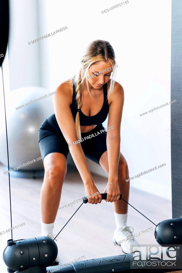 Photo de stock: Young sportswoman doing suspension training in gym.