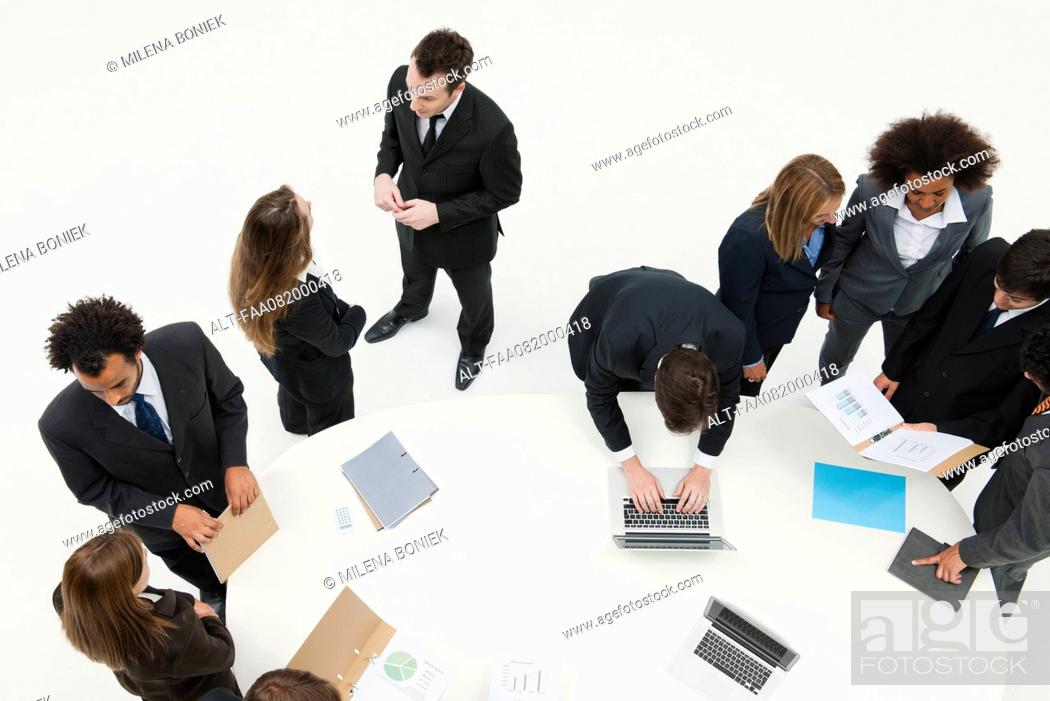 Stock Photo: Business associates working together in small groups around table.