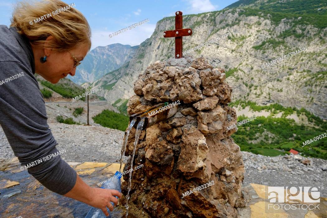 Stock Photo: Woman fills in water from a confined source at Selca, Kelmend region, Albanian Alps, Prokletije, Qark Shkodra, Albania.