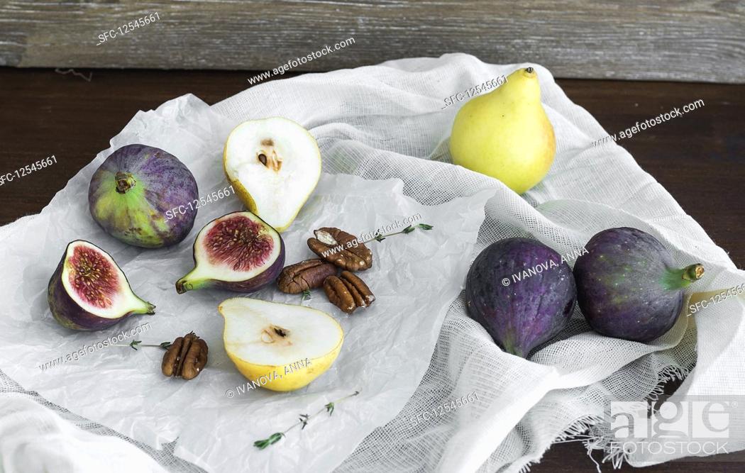 Stock Photo: Figs, pears and pekan nuts on a white tissue on a wooden table surface.
