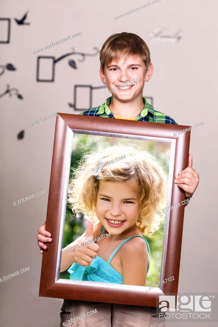 Stock Photo: Happy brother holding portrait with his sister each is located inside her own frame.