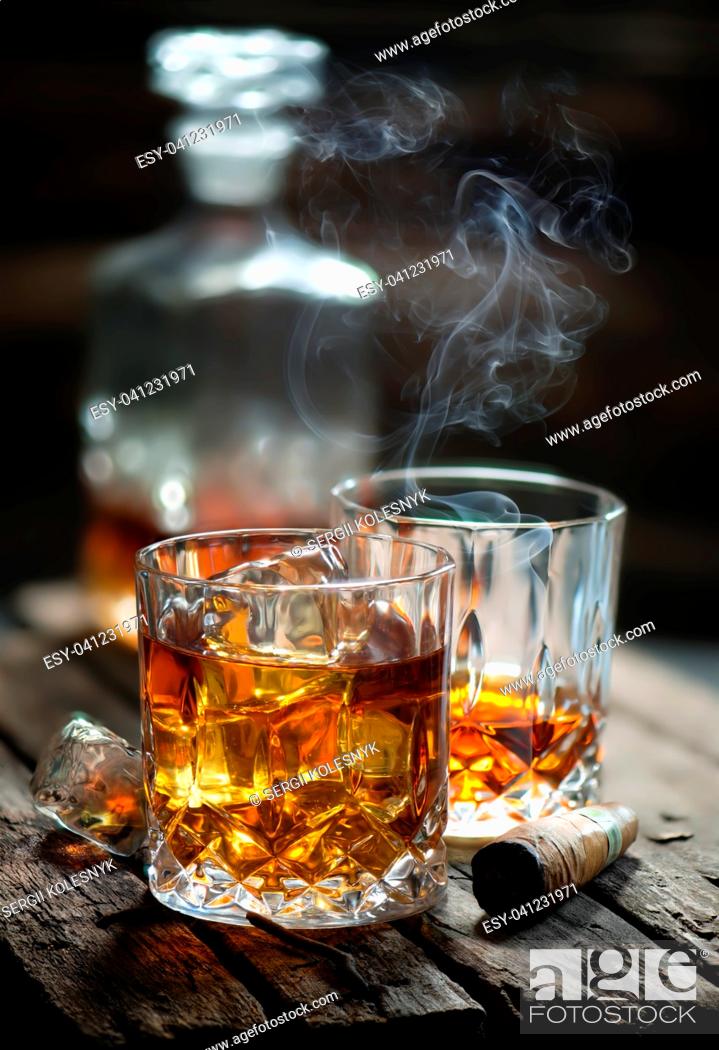Stock Photo: Cigar and glass with whiskey with ice cubes.