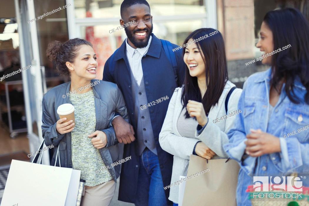 Imagen: Smiling friends with coffee and shopping bags.