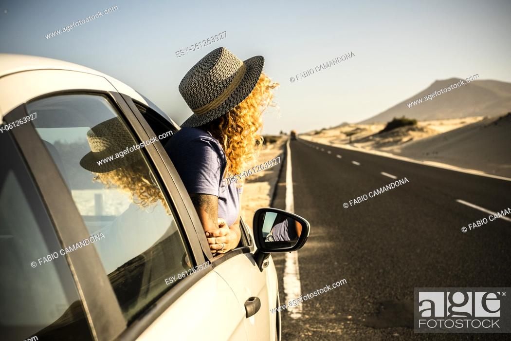 Photo de stock: Tourist enjoy sun and outdoors outside the window of the car during a break. Vehicle parking on the side of the road and woman people admiring landscape.