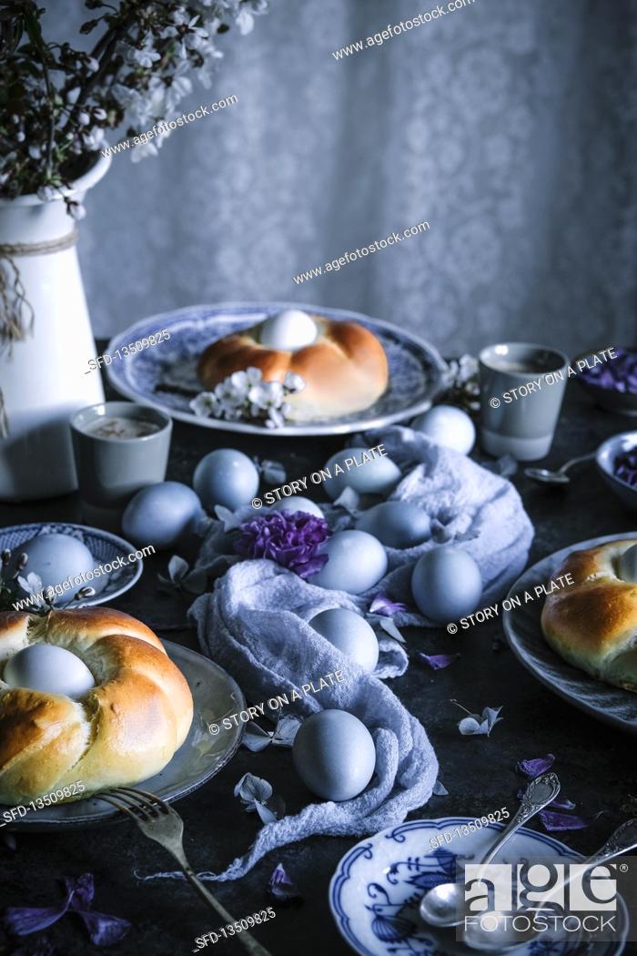 Stock Photo: Easter table with coloured eggs and yeast wreath.