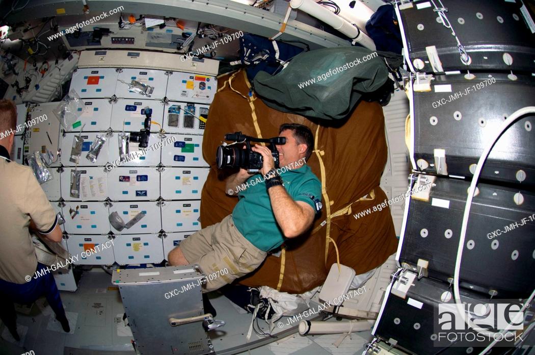 Imagen: Astronaut Steve Bowen, STS-126 mission specialist, uses a video camera on the middeck of Space Shuttle Endeavour while docked with the International Space.