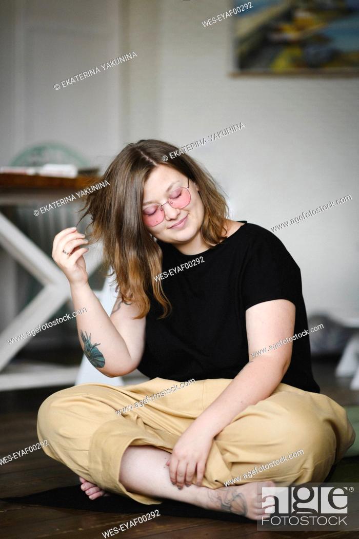 Stock Photo: Portrait of tattooed woman sitting on the floor at home.