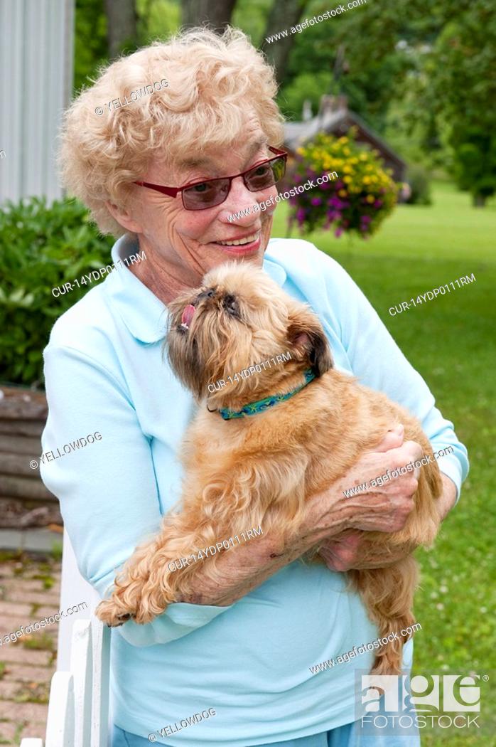 Stock Photo: mature woman hugging her brussels griffon dog.