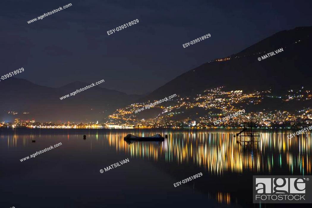 Stock Photo: Alpine lake at night with cityscape and reflection.