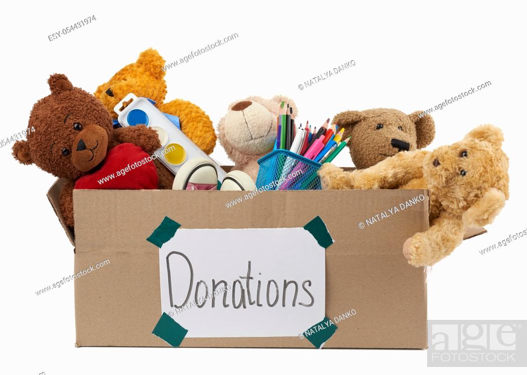 Stock Photo: brown cardboard box filled with soft toys, school supplies isolated on white background, concept of charity and help to needy children.