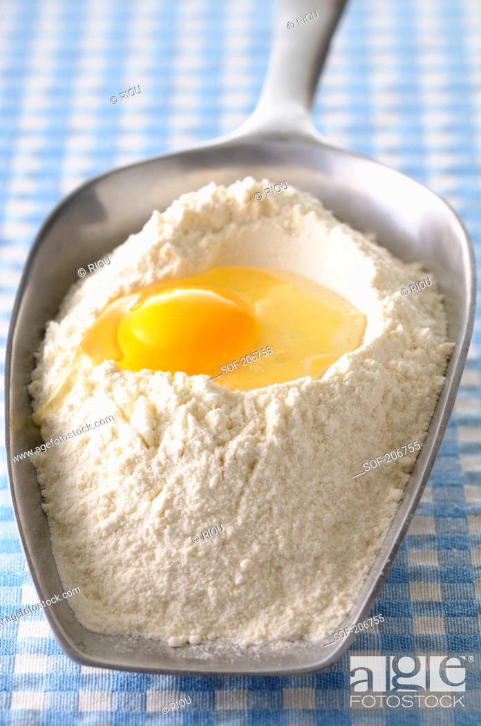 Stock Photo: Scoopful of flour and a broken egg.