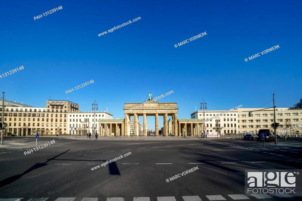 Stock Photo: 23.03.2020, the Brandenburg goal in Berlin on a late spring juice day in the low sun. The sun shines through the prophylaxis and creates a special mood of light.
