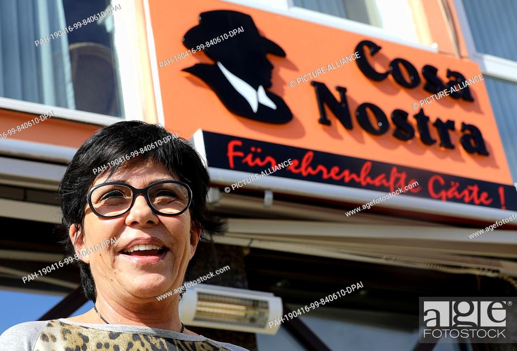 Stock Photo: 18 March 2019, North Rhine-Westphalia, Köln: Petra Bratu, owner of the Italian restaurant ""Cosa Nostra"", stands in front of the restaurant and smiles.