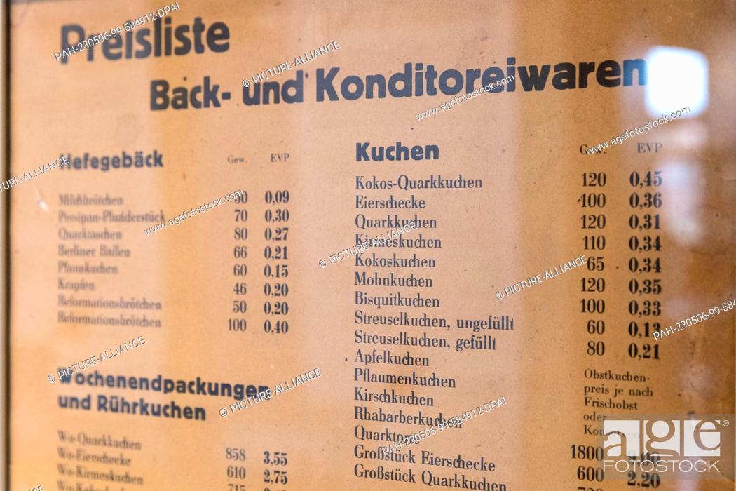 Stock Photo: 06 May 2023, Brandenburg, Lübbenau: Behind glass hangs a price list for baked goods and confectionery. Food was subsidized in the GDR and was very cheap.