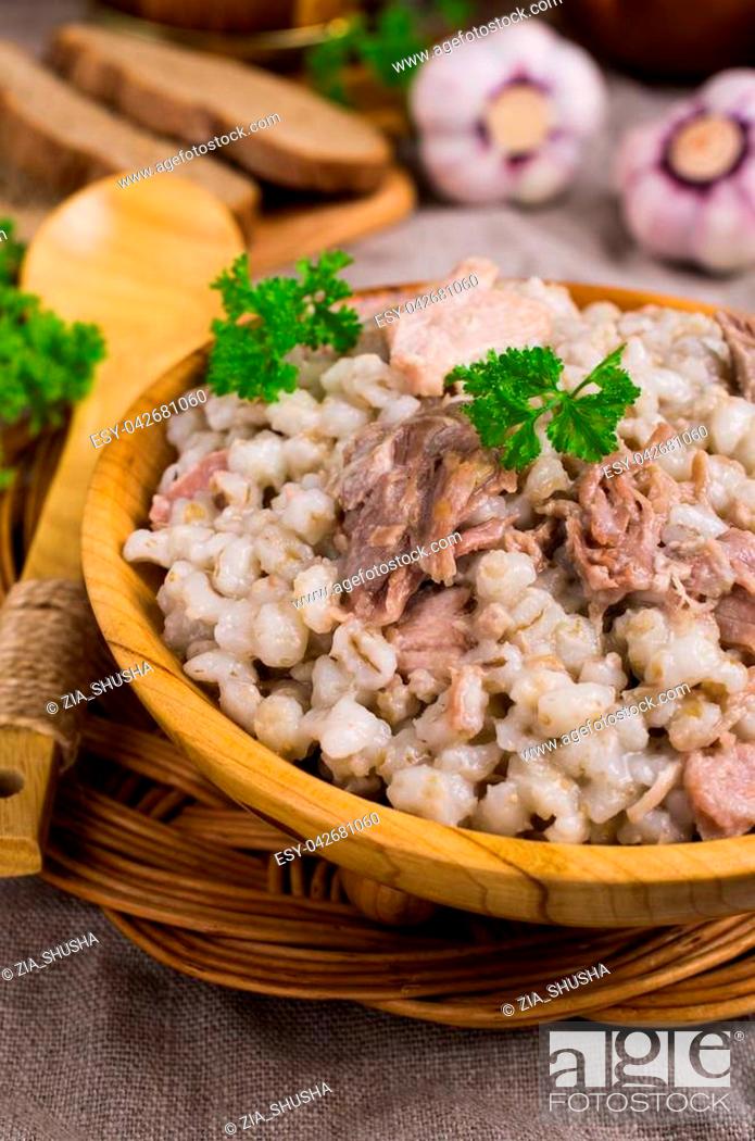 Stock Photo: Traditional pearl barley porridge with meat in a dish on the table. Selective focus.