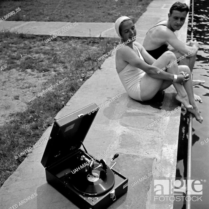 Stock Photo: Ein junges Paar sitzt im Freibad am Beckenrand und hört die neuesten Schlager auf einem Elextrole Grammophon, Deutschland 1930er Jahre.