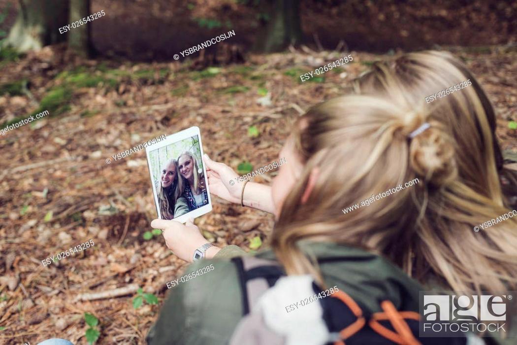 Stock Photo: Twin sister making selfie in forest. Over shoulder shot.