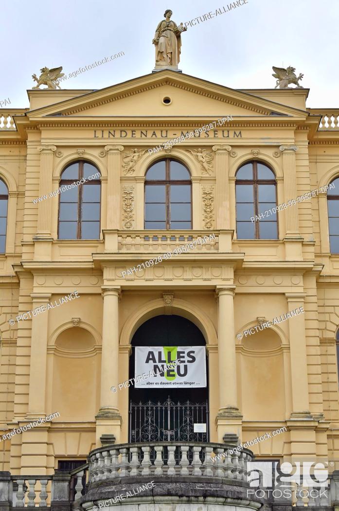 Stock Photo: 28 September 2021, Thuringia, Altenburg: ""Everything new ...but it will take a little longer..."" is written on a banner at the portal of the vacant Lindenau.