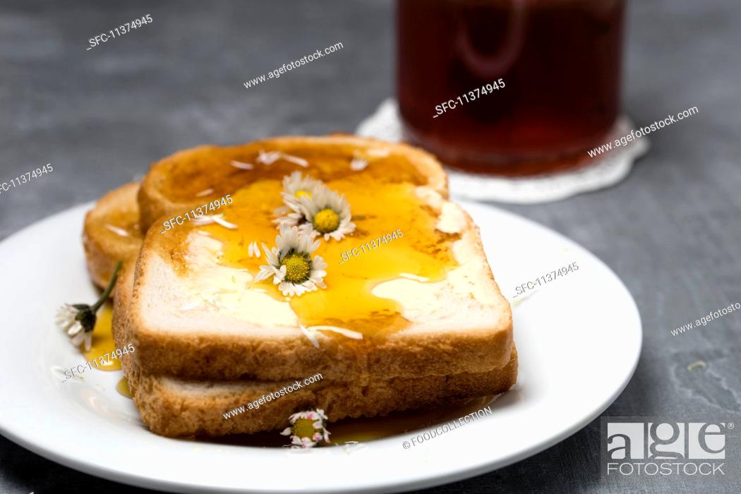 Stock Photo: Slices of toast with honey and daises.