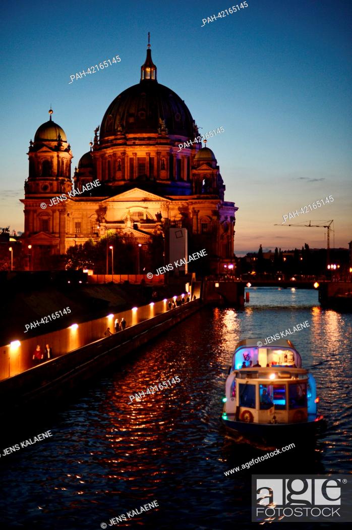 Stock Photo: The illuminated Berlin Cathedral and a tour ship are pictured from the Town Hall Bridge above the Spree river in the evening of 24 August 2013 in Berlin.