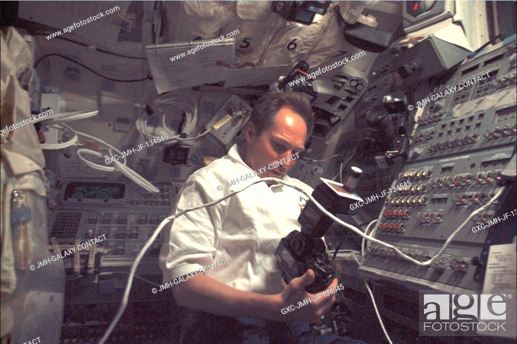 Stock Photo: Cosmonaut Valery I. Tokarev, one of five mission specialists aboard Discovery, checks out a camera which is to be used later from this flight deck position to.