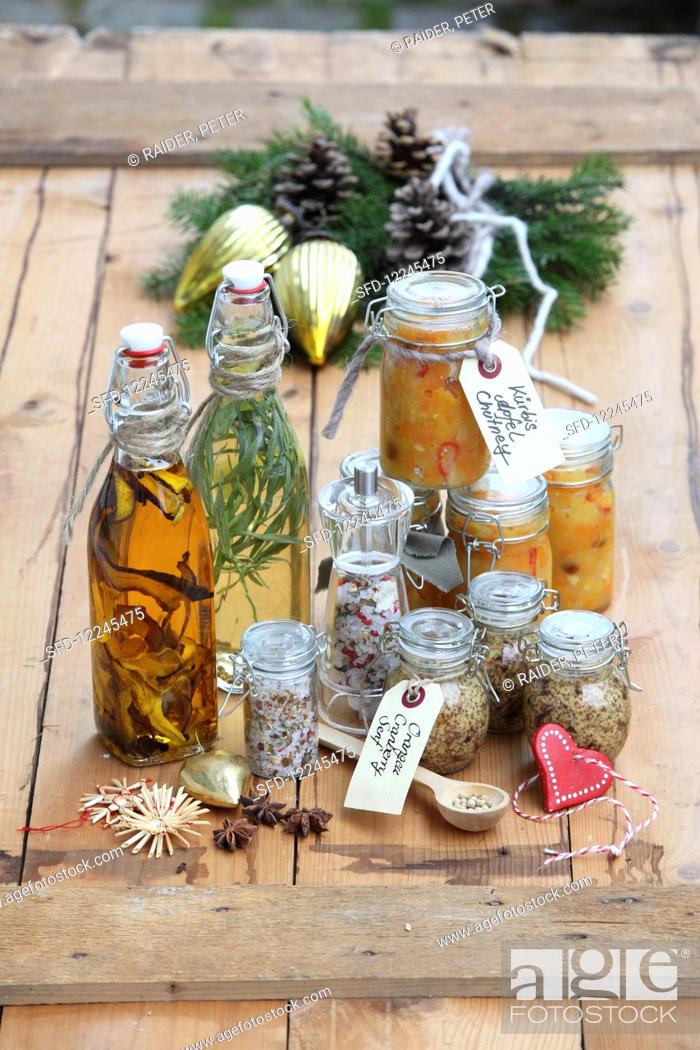 Stock Photo: Various homemade Christmas gifts: porcini mushroom and thyme salt, tarragon vinegar, porcini oil, orange and cranberry mustard and pumpkin and apple chutney.