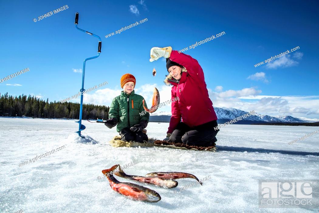 Stock Photo: Mother with son ice fishing.