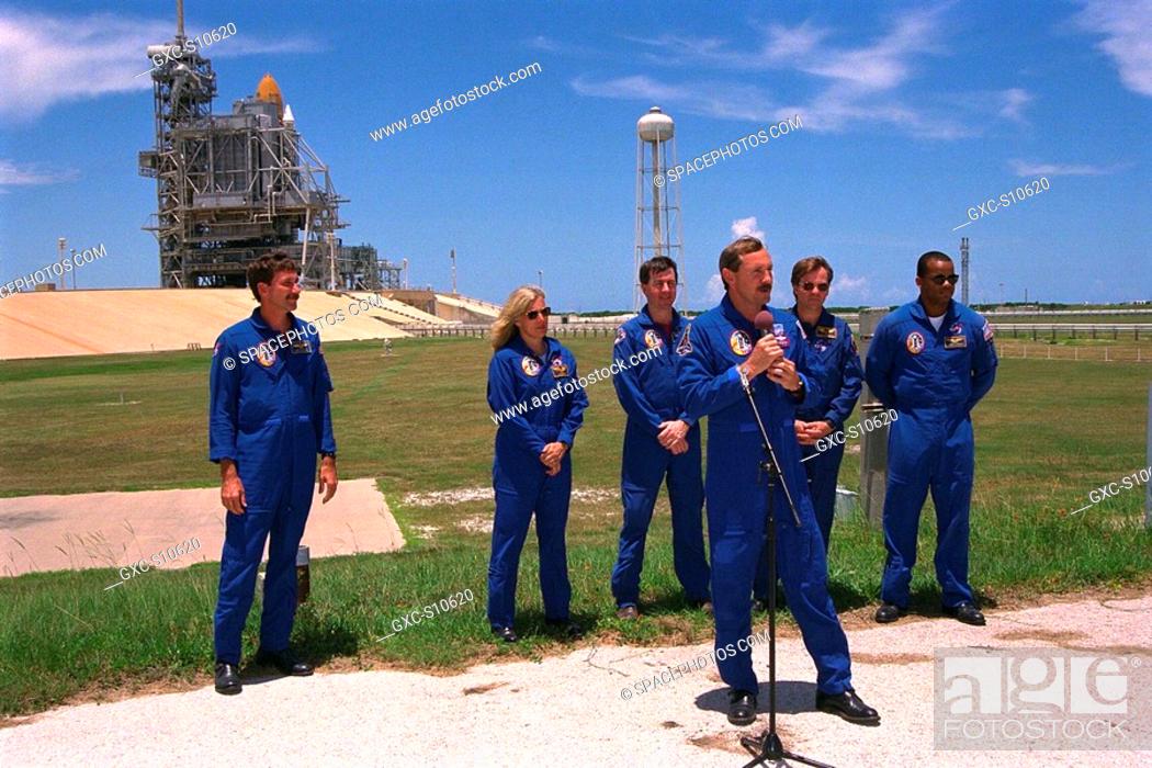 Stock Photo: 07/22/1997 -- STS-85 Commander Curtis L. Brown, Jr., addresses the news media at a briefing at Launch Pad 39A while the other members of the flight crew in the.