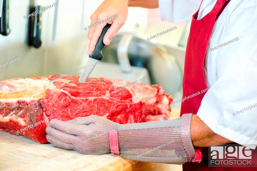 Stock Photo: Butcher cutting up beef.