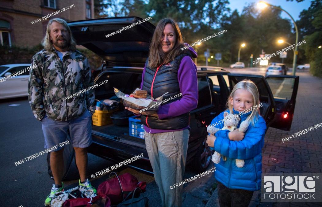 Stock Photo: The family Jan Bauer (L-R), Bianca Winterhalter and daughter Lina Bauer (7) pack their car to leave the evacuation zone in Frankfurt am Main, Germany.