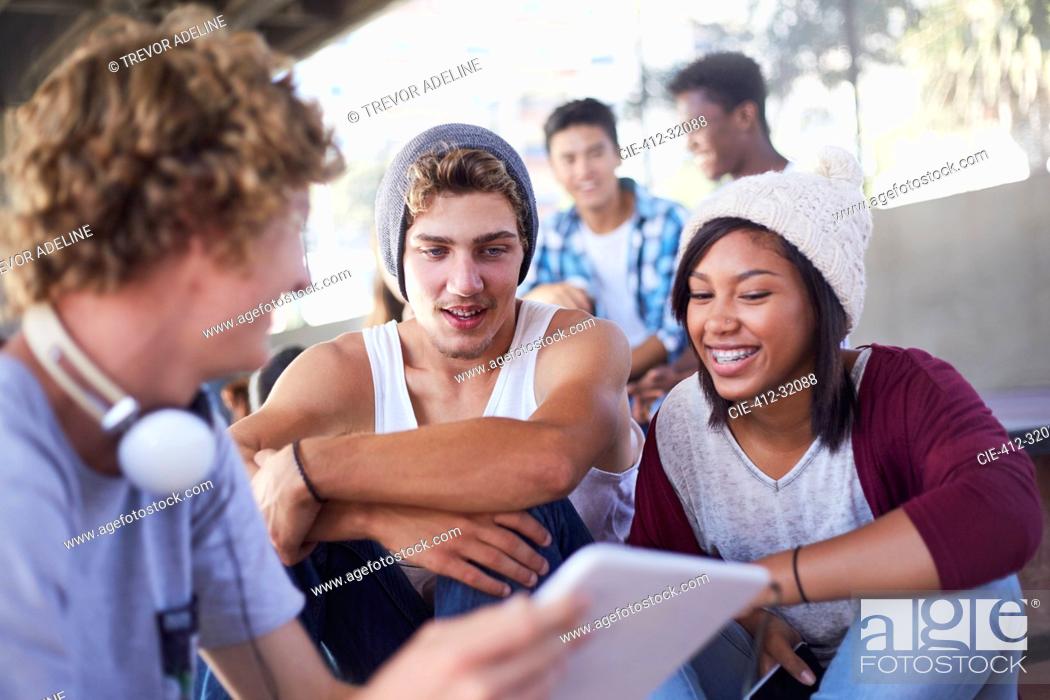 Stock Photo: Teenage friends hanging out using digital tablet.