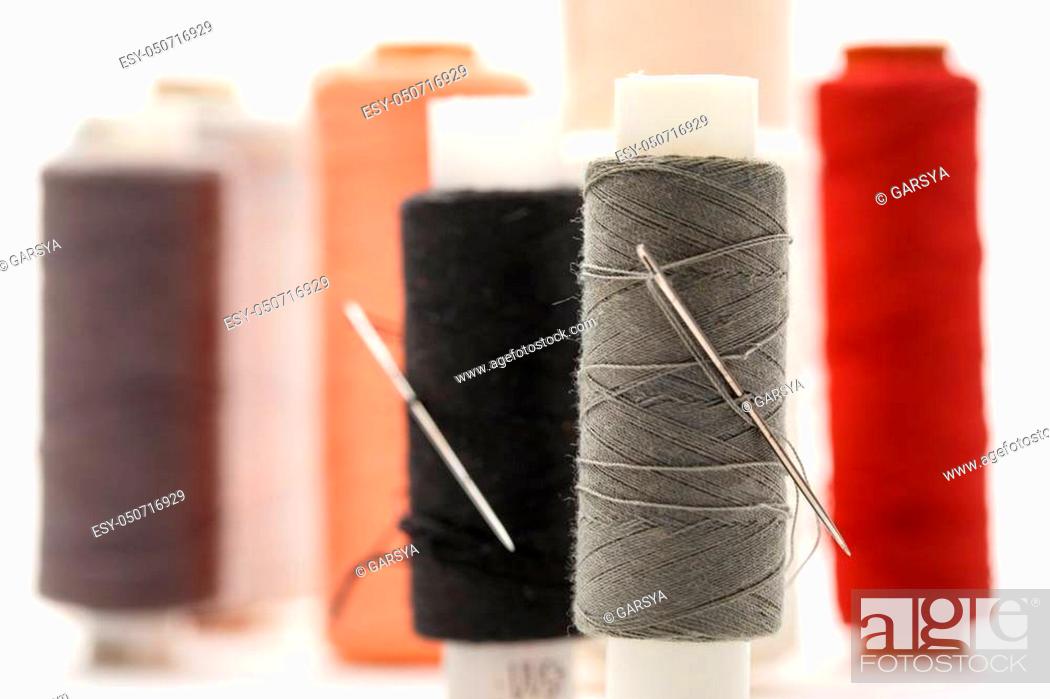 Stock Photo: Thread bobbins and needles on white background.