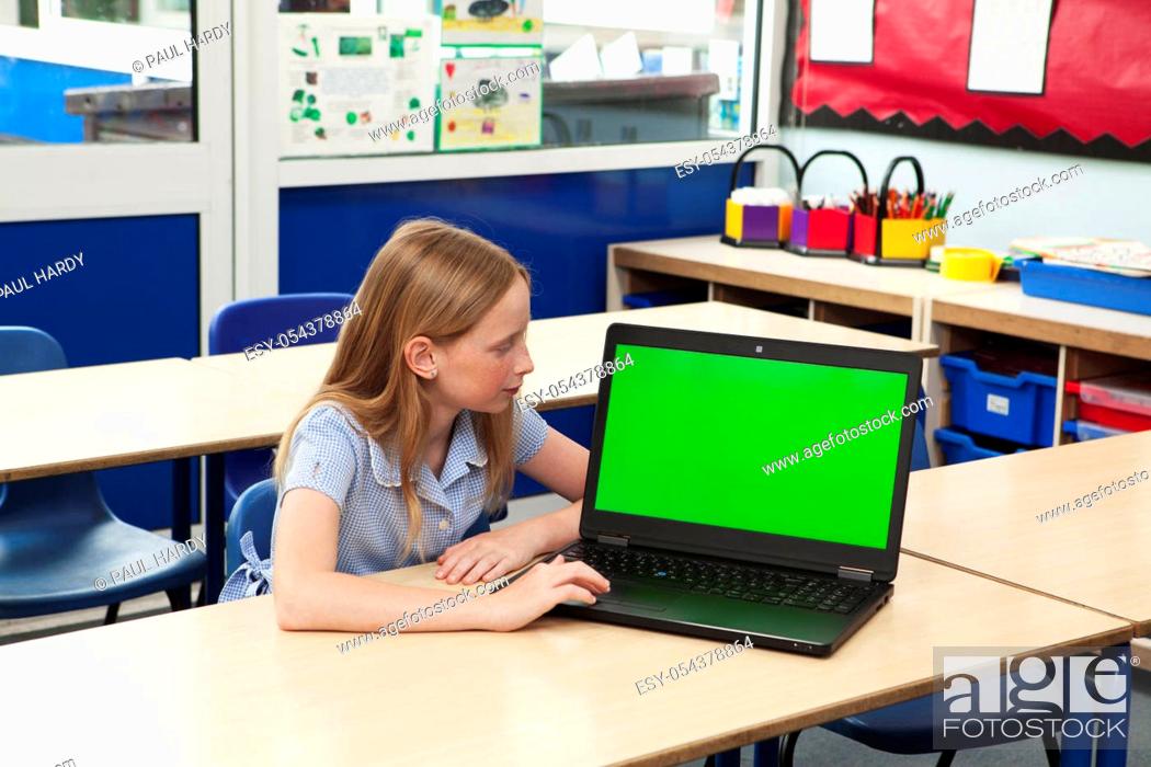 Stock Photo: Caucasian primary school girl with a computer with a green screen themes of chromakey education student technology future.