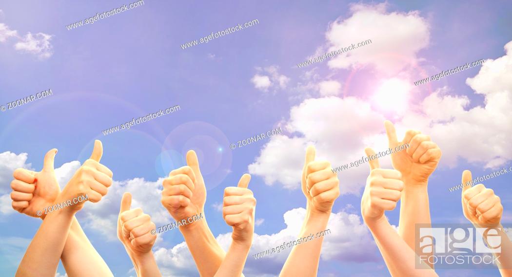 Stock Photo: Thumbs and hands up in front of sky with sunshine.