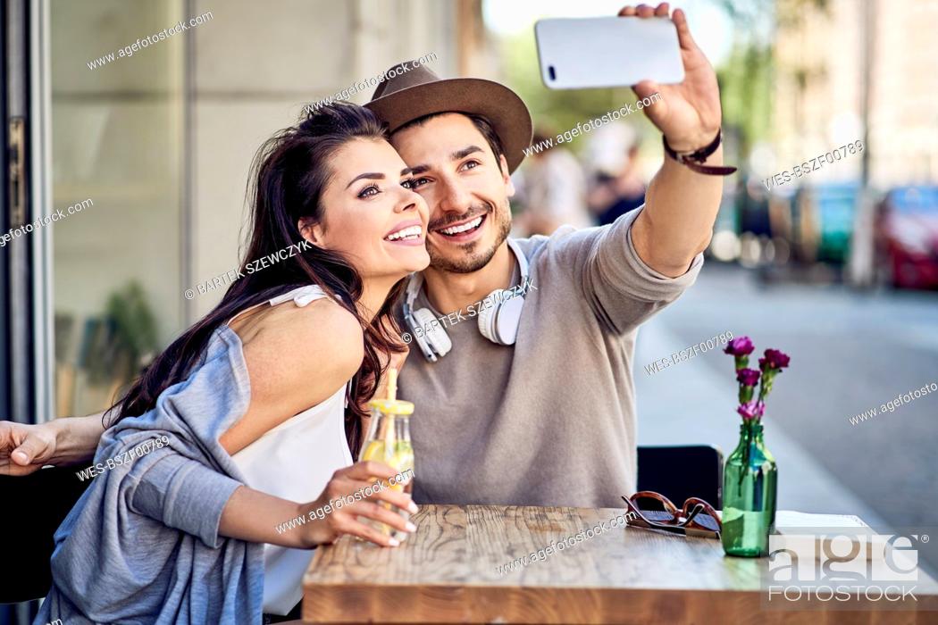 Stock Photo: Happy young couple taking a selfie at outdoors cafe.